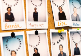 A row of polaroid photographs pinned to a corkboard. Each photo shows a volunteer's face and has their name handwritten below.