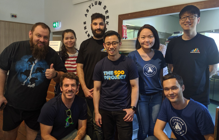 A team of eight colleagues from Atlassian stand inside the Asylum Seekers Centre doing volunteer work