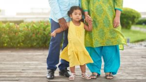 A South Asian man, woman and toddler daughter.