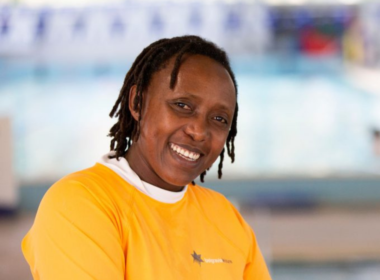 An African woman wearing a swimming instructor outfit at a swimming pool