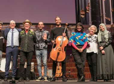 Musicians stand on stage at Sydney Town Hall, during a Refugee Week event