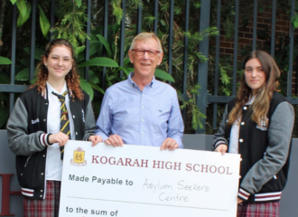 Community speaker with school students and a big cheque