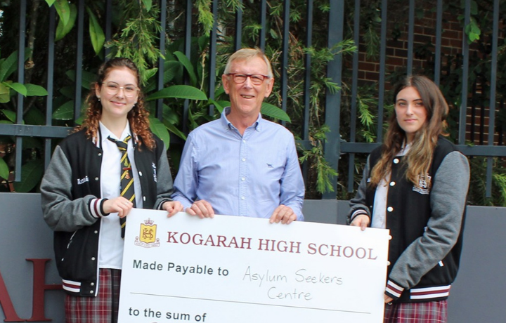 Community speaker with school students and a big cheque