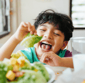 A little boy eating lettuce
