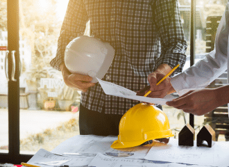 men with hard hats looking at a piece of paper