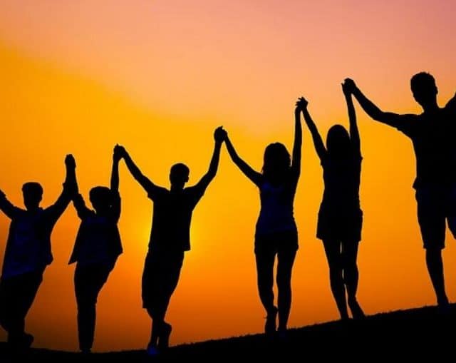 stock image of people holding hands in the sunset