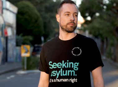 Man wearing "Seeking asylum is a human right" shirt