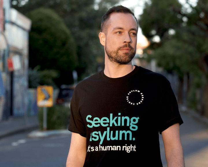 Man wearing "Seeking asylum is a human right" shirt