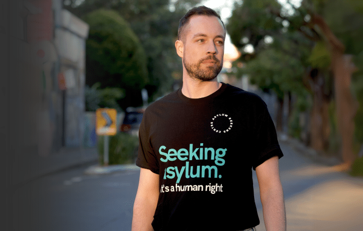 Man wearing "Seeking Asylum. It's a human right." shirt