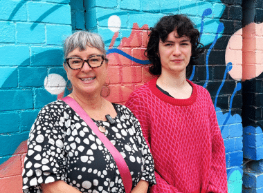 Mom and daughter leaning on mural