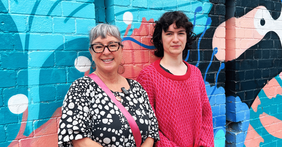 Mom and daughter leaning on mural